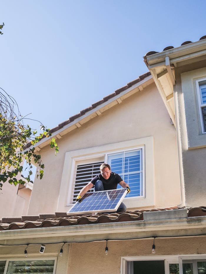 about-01 A worker installs a solar panel on a residential rooftop, showcasing renewable energy technology.